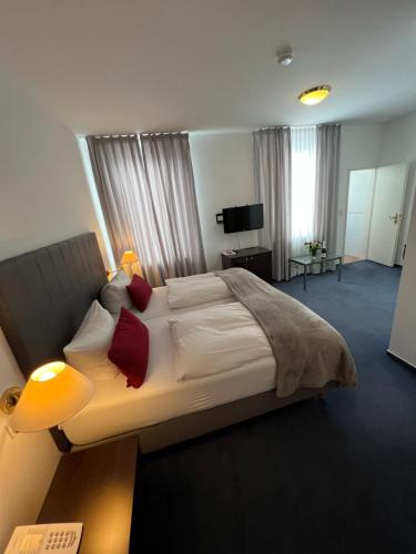1 dormitorio con 1 cama grande con almohadas rojas en Hotel zum Ritter St. Georg, en Heidelberg