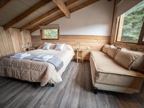 a bedroom with a bed and a couch in a room at Cielo Sur Balsas Loft in Villa La Angostura