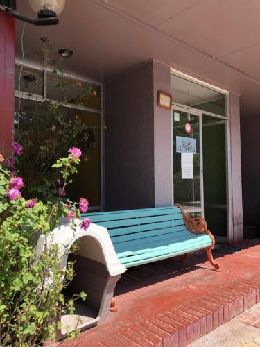 a blue bench sitting outside of a building at Hotel Las Vicuñas in Putre