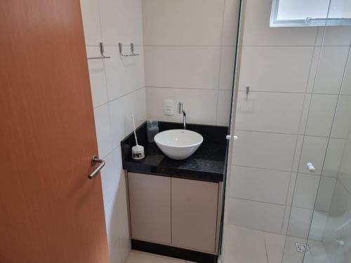 a bathroom with a sink and a glass shower at Apartamento em Condomínio Frente Mar Barra Velha-SC in Barra Velha