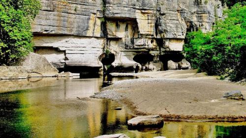 a body of water with a cave in the background at Gite le Chamaju in Labeaume