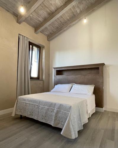 1 dormitorio con 1 cama grande y cabecero de madera en Locanda en Gessate
