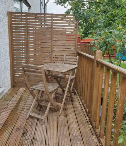 a wooden table and chair on a wooden deck at M-Hotels Apartments in London