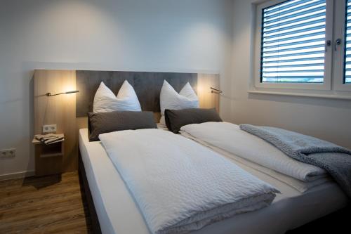 1 Schlafzimmer mit 2 Betten mit weißer Bettwäsche und einem Fenster in der Unterkunft Livin63 Studio Apartments in Hösbach
