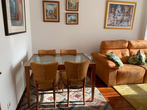 a dining room with a glass table and a couch at Apartamento Conchita in Vigo
