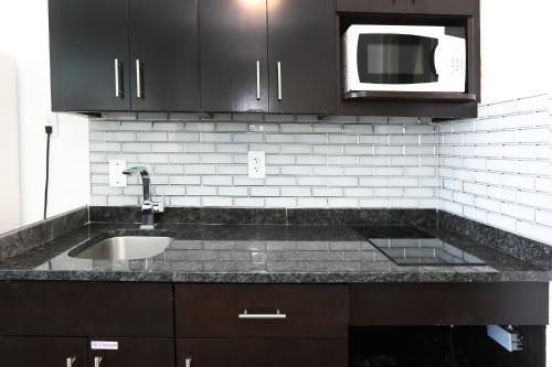 a kitchen with a sink and a microwave at Olympic Island Beach Resort in Wildwood Crest