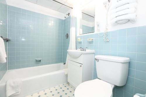 a bathroom with a toilet and a sink and a tub at Olympic Island Beach Resort in Wildwood Crest