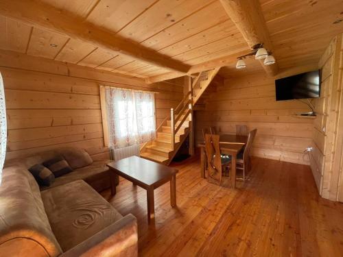 a living room with a couch and a table in a cabin at Domek u Orszulaków in Witów