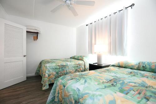 a bedroom with two beds and a ceiling fan at Olympic Island Beach Resort in Wildwood Crest