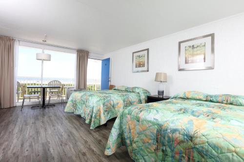 a hotel room with two beds and a table at Olympic Island Beach Resort in Wildwood Crest