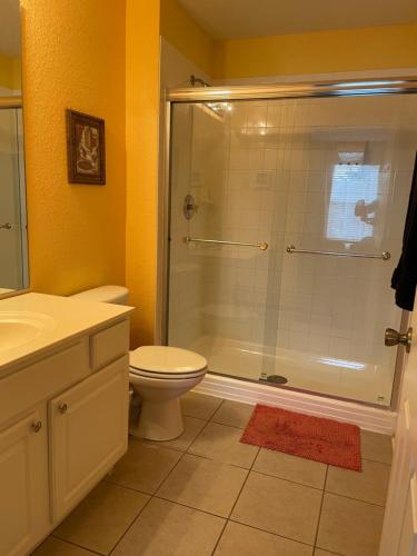 y baño con ducha, aseo y lavamanos. en Windsor Hill Resort Home w Pool, 5 Min from Disney, en Orlando