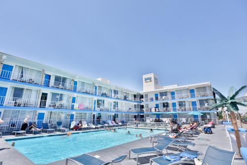 a hotel with a swimming pool and chairs and a resort at Olympic Island Beach Resort in Wildwood Crest