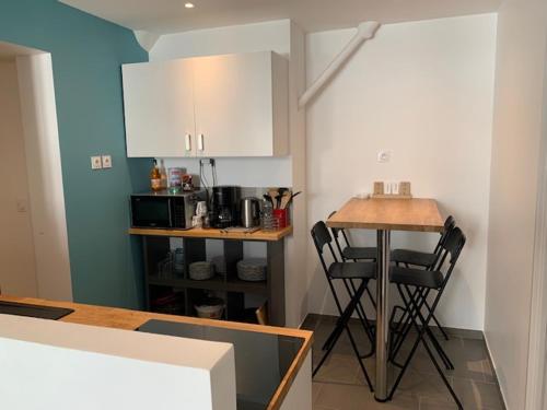 une cuisine avec une table et deux chaises noires dans l'établissement Appartement 4 chambres centre-ville, à Bourg-en-Bresse