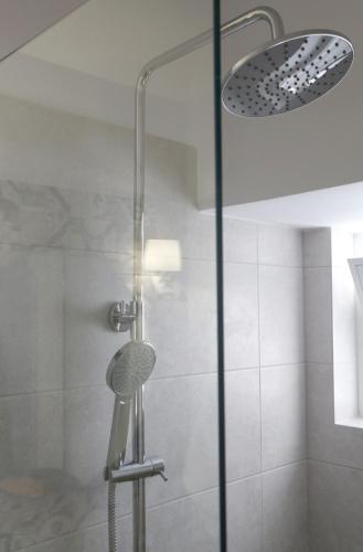 a shower with a glass door and a shower head at Central Cozy Residences in Sitia