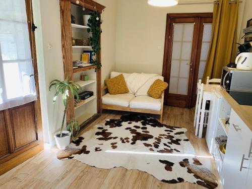 a living room with a cow rug on the floor at Gîte: À la courbe du fleuve in Godinne