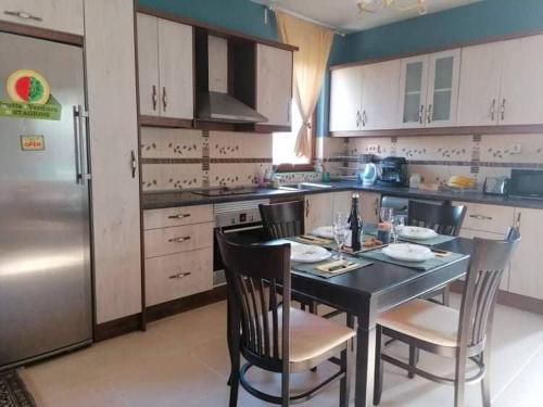 a kitchen with a table and chairs and a refrigerator at River Hills Guest House in Lesichevo