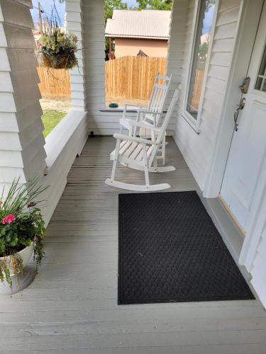 a porch with a rocking chair and a door at Holland House - Historic and Sophisticated in Alpine