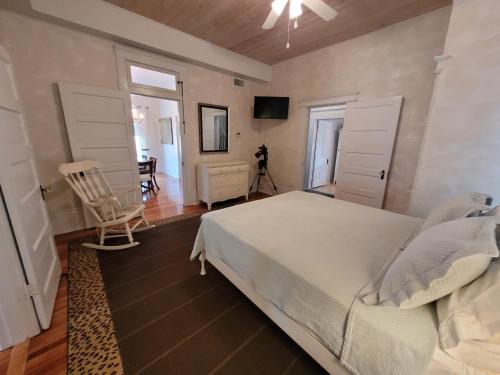 a bedroom with a white bed and a table at Holland House - Historic and Sophisticated in Alpine