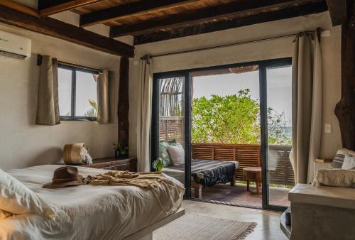 a bedroom with a bed and a sliding glass door at Amansala Resort in Tulum