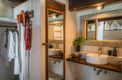 a bathroom with two sinks and a mirror at Amansala Resort in Tulum