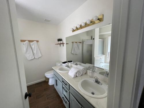 łazienka z 2 umywalkami, toaletą i lustrem w obiekcie Vista Retreat - Country Club Estates w mieście Sierra Vista