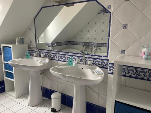La salle de bains est pourvue de 2 lavabos et d'un grand miroir. dans l'établissement Le Char'Mans, cocon suréquipé en centre ville, au Mans