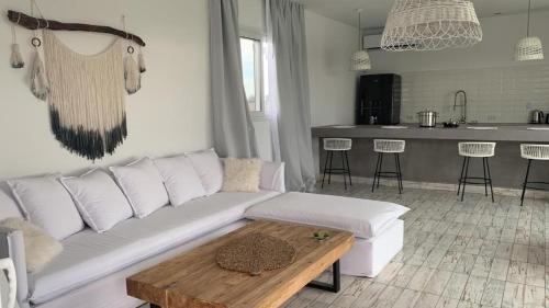 sala de estar con sofá blanco y mesa en El Nido en Azcuénaga