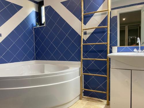 Baño azul con bañera y lavamanos en mas des cèdres, en Tarascon