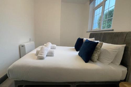 a large white bed with blue and white pillows at Suite 1- Luxury 1 Bed Apt- Leicester City- Free Parking in Leicester