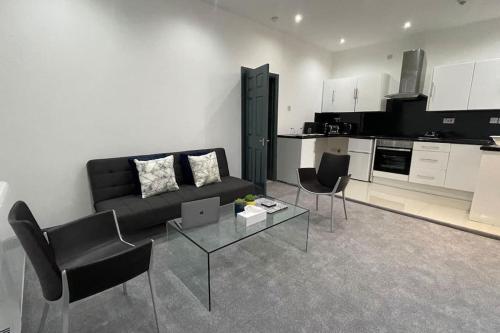 uma sala de estar com um sofá, cadeiras e uma mesa em Suite 1- Luxury 1 Bed Apt- Leicester City- Free Parking em Leicester