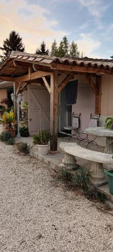 une pergola en bois avec un banc et une table dans l'établissement Logement TypeF2 meublé, à Saint-Avit-Saint-Nazaire