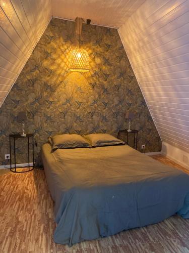 sypialnia z łóżkiem z kamienną ścianą w obiekcie Grange Rousselin w mieście Bachivillers