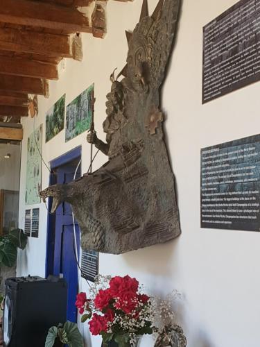 a statue of a ship hanging on a wall with flowers at Casona Mollepata in Mollepata
