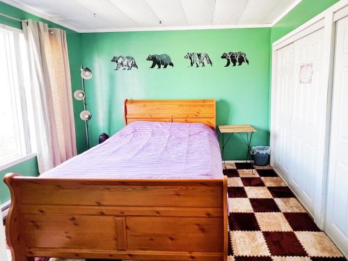 a bedroom with a wooden bed in a green wall at Sarah's dreamhouse B&B in Churchill