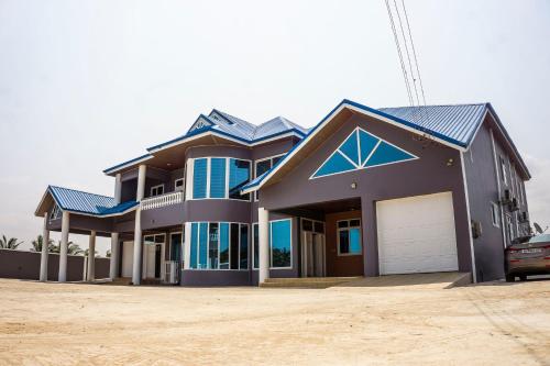 a house with a car parked in front of it at Moven Paradise in Accra