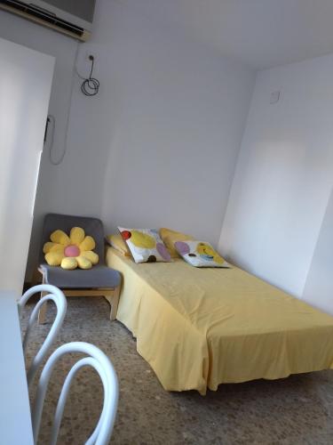a bedroom with a bed and a chair with pillows at Alojamiento -Estudio Centro Dos Hermanas in Dos Hermanas