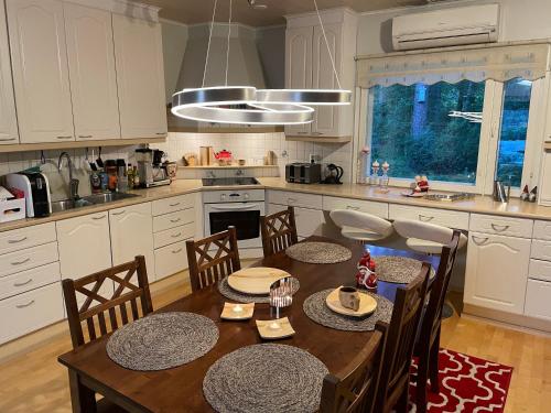 uma cozinha com uma mesa de madeira com cadeiras e uma sala de jantar em Blue Dream House em Rovaniemi