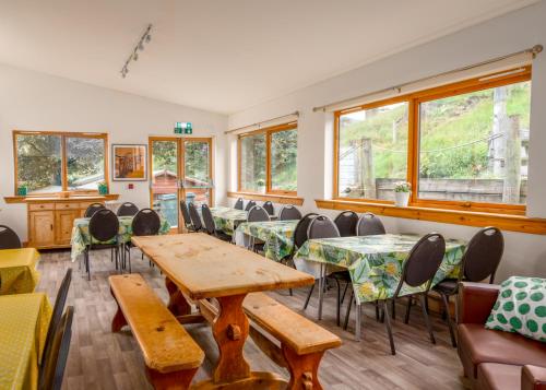 een kamer met tafels, stoelen en ramen bij Gulabin Lodge in Glenshee