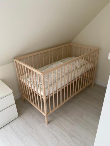 - un lit bébé dans l'angle de la chambre dans l'établissement Casa Luisa - Trzęsacz, à Trzęsacz