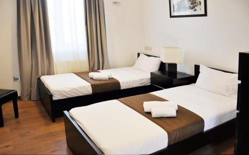 a hotel room with two beds with white sheets at Millennium Tbilisi in Tbilisi City