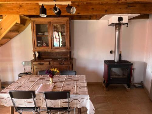 - une salle à manger avec une table et un poêle à bois dans l'établissement Le col de Perjuret, à Fraissinet-de-Fourques