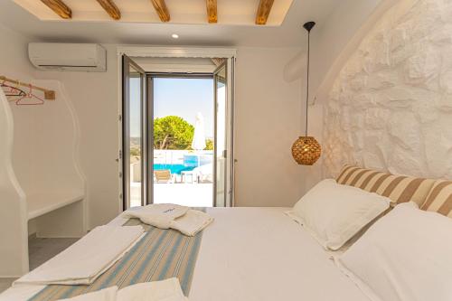 a bedroom with a bed and a view of a pool at Kallithea Hotel in Agia Anna Naxos