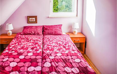 a bedroom with a pink bed with two night stands at Stunning Home In Golubie With Wifi in Gołubie