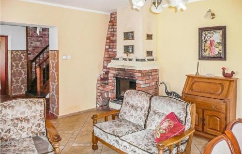 a living room with a couch and a fireplace at Nice Home In Pl-76-113 Postomino in Korlino