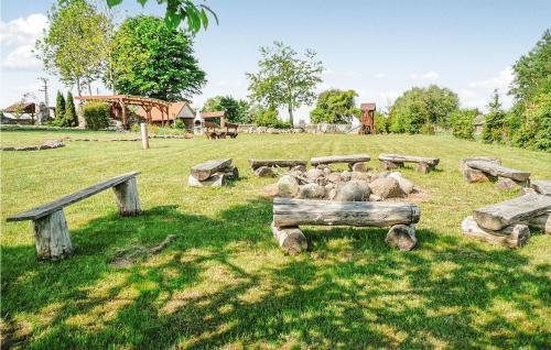a herd of sheep in a field with logs at Nice Home In Pl-76-113 Postomino in Korlino