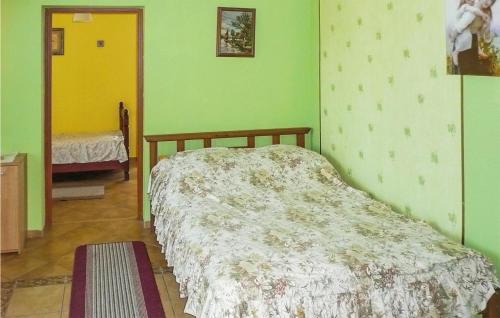 a bedroom with a bed in a room with green walls at Nice Home In Pl-76-113 Postomino in Korlino
