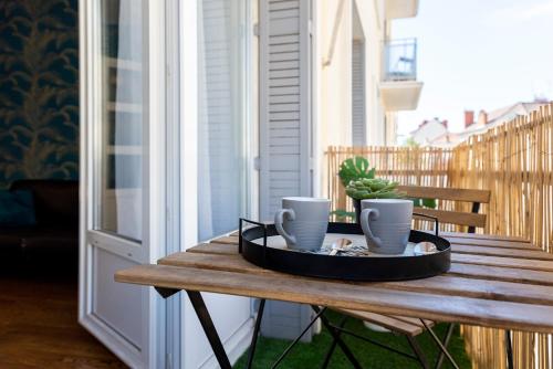 - une table sur une terrasse couverte avec un plateau de tasses à café dans l'établissement 