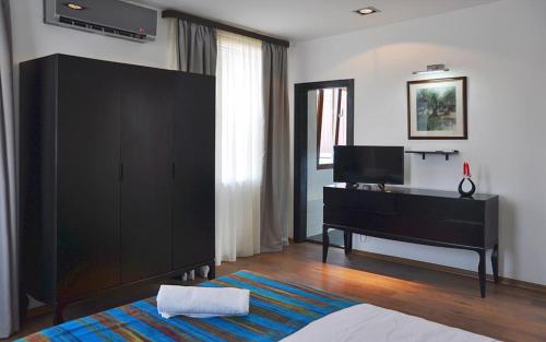 a bedroom with a black dresser and a piano at Millennium Tbilisi in Tbilisi City