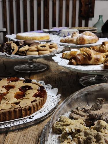 a table full of pies and pastries on plates at il Glicine B&B RISTORANTE in Cazzago San Martino