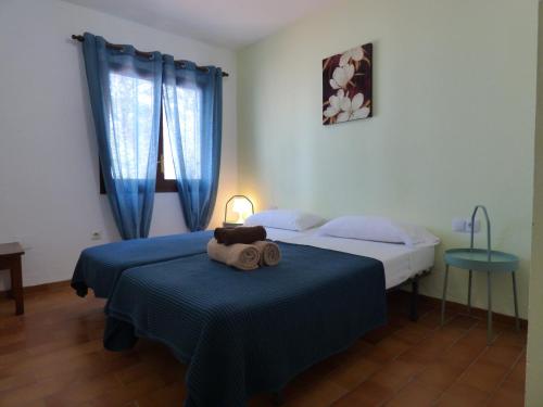 um quarto com 2 camas com lençóis azuis e uma toalha em Rigel Es Pujols em Es Pujols